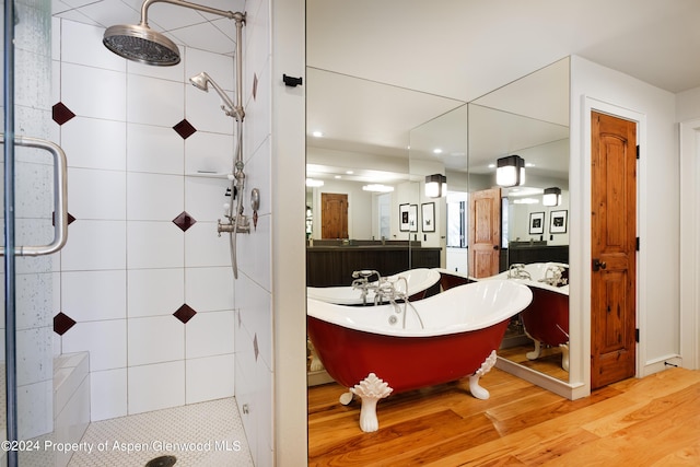 bathroom with hardwood / wood-style floors, vanity, and separate shower and tub