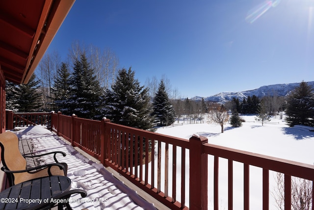 snow covered deck with a mountain view