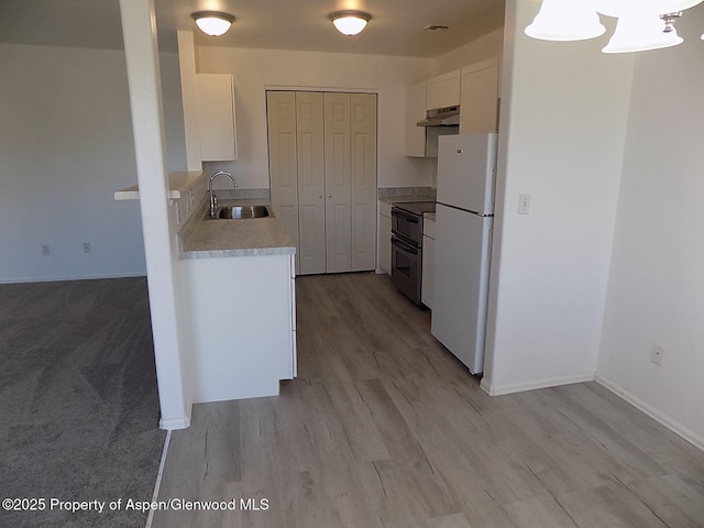33 Angelica Cir, Parachute, CO 81635 - kitchen with under cabinet range hood, freestanding refrigerator, double oven range, light countertops, and white cabinets