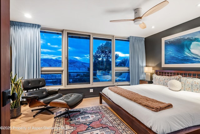 bedroom with a mountain view and a ceiling fan