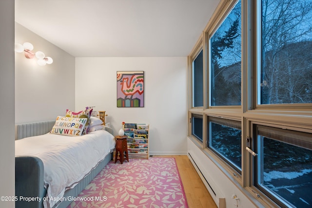 bedroom featuring baseboard heating and light wood-type flooring