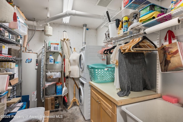 storage room featuring stacked washer and dryer, electric water heater, and visible vents