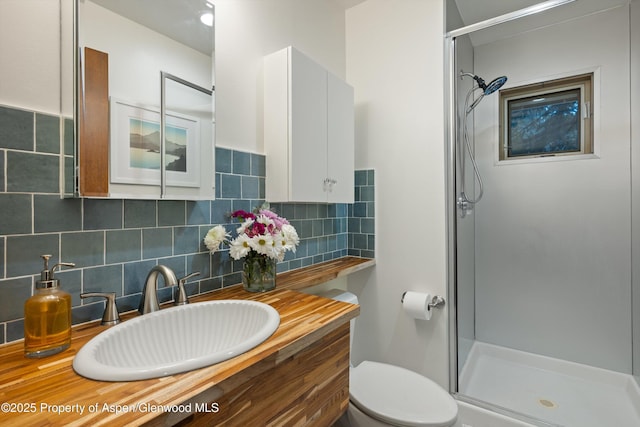 bathroom with tasteful backsplash, a stall shower, and toilet