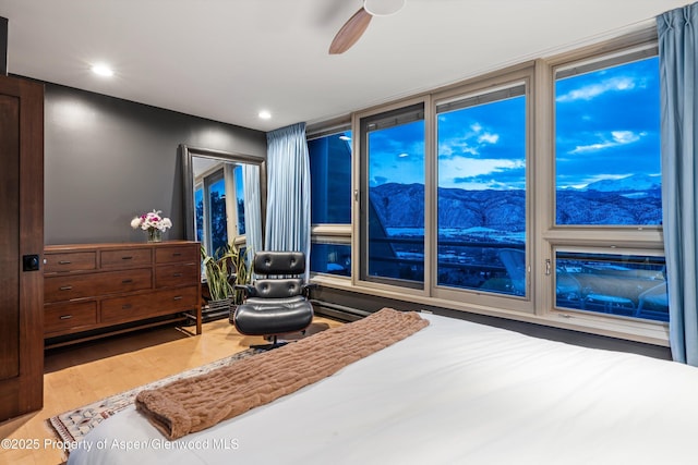 bedroom with ceiling fan, wood finished floors, a mountain view, and recessed lighting