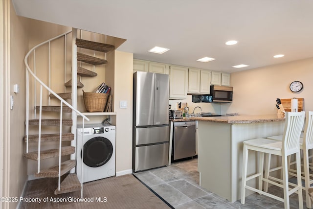 800 S Mill St Unit 301C, Aspen, CO 81611 - kitchen featuring stainless steel appliances, a breakfast bar, light stone counters, recessed lighting, and a peninsula