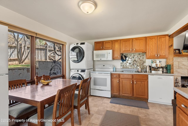 534/536 Spruce St, Aspen, CO 81611 - kitchen featuring white appliances, stacked washer / dryer, light countertops, and brown cabinetry