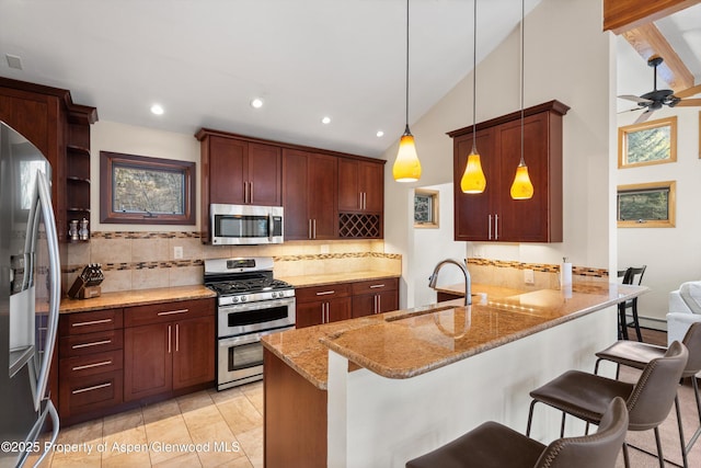 534/536 Spruce St, Aspen, CO 81611 - kitchen with stainless steel appliances, a peninsula, tasteful backsplash, a kitchen bar, and high vaulted ceiling