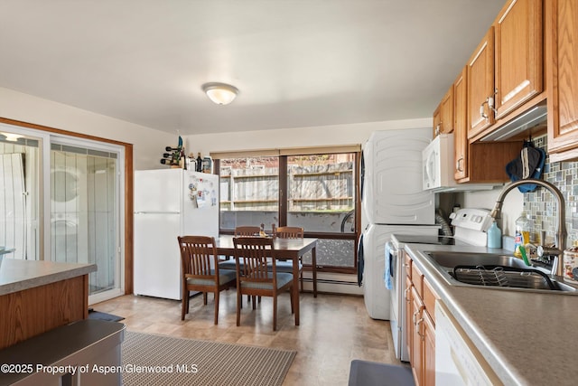 534/536 Spruce St, Aspen, CO 81611 - kitchen with white appliances, stacked washer and clothes dryer, and brown cabinets