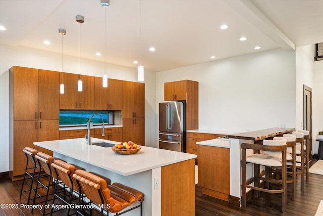 103 Ranch Ln, Glenwood Springs, CO 81601 - kitchen featuring high quality fridge, brown cabinets, a sink, dark wood-style floors, and a breakfast bar area