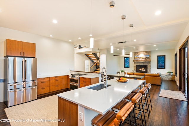 103 Ranch Ln, Glenwood Springs, CO 81601 - kitchen featuring appliances with stainless steel finishes, open floor plan, dark wood-style floors, brown cabinets, and a sink