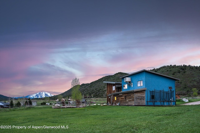 103 Ranch Ln, Glenwood Springs, CO 81601 - back of property at dusk with a mountain view and a yard