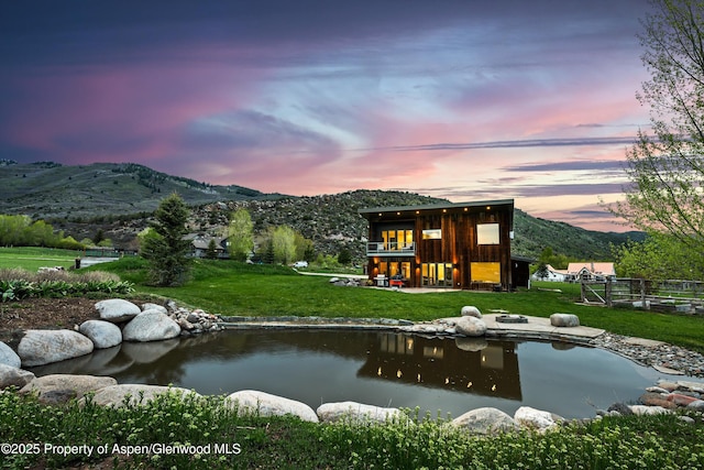 103 Ranch Ln, Glenwood Springs, CO 81601 - back of house at dusk featuring a mountain view and a garden pond