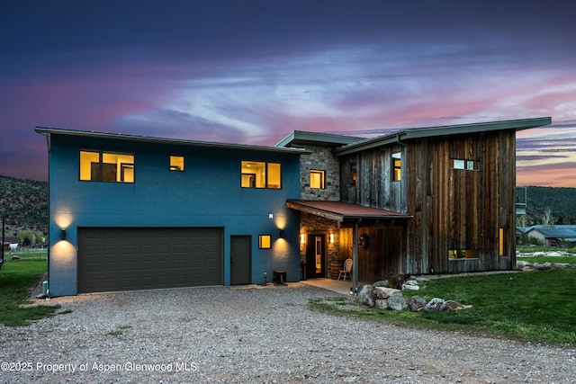 103 Ranch Ln, Glenwood Springs, CO 81601 - view of front of house featuring an attached garage, driveway, stucco siding, and stone siding