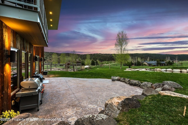 103 Ranch Ln, Glenwood Springs, CO 81601 - patio terrace at dusk featuring a lawn