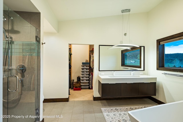 103 Ranch Ln, Glenwood Springs, CO 81601 - bathroom with a stall shower, a spacious closet, baseboards, double vanity, and tile patterned flooring