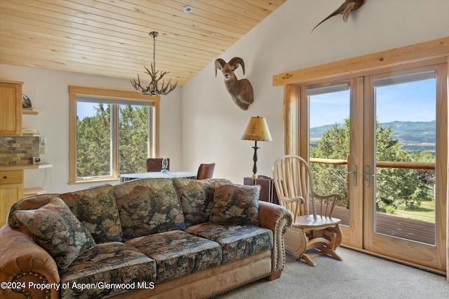 carpeted living room with a mountain view, wood ceiling, a chandelier, and vaulted ceiling