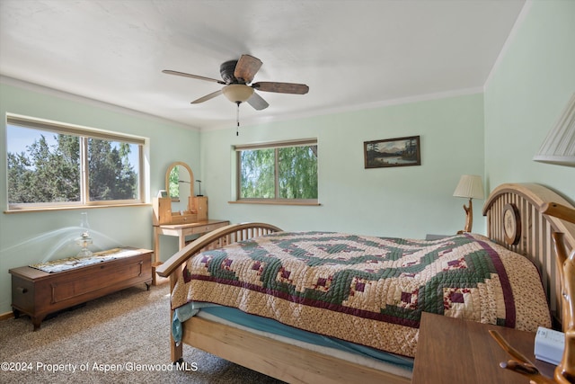 carpeted bedroom with ceiling fan and crown molding