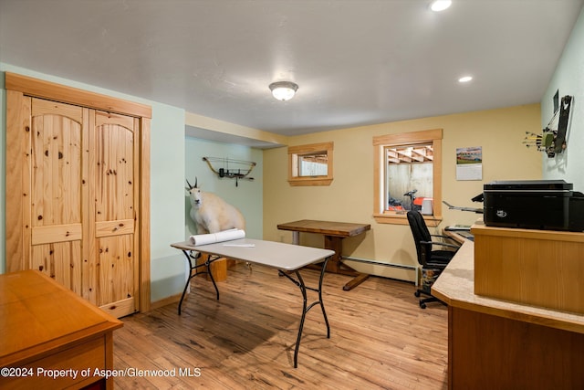 office space with light hardwood / wood-style flooring and a baseboard heating unit