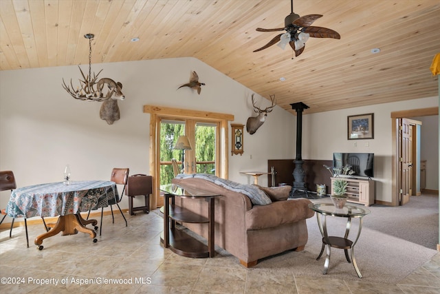 living room featuring vaulted ceiling, a wood stove, ceiling fan, and wooden ceiling