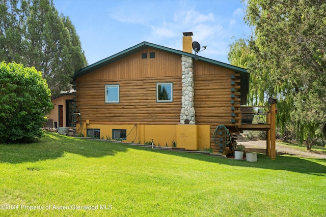 back of house featuring a yard and a wooden deck