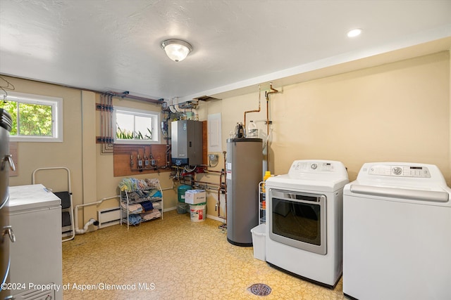 laundry area with electric panel, separate washer and dryer, a baseboard radiator, and water heater