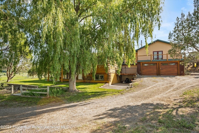 view of property hidden behind natural elements with a front yard and a wooden deck