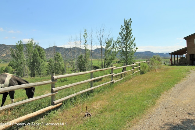 view of yard featuring a mountain view, a rural view, and an outdoor structure