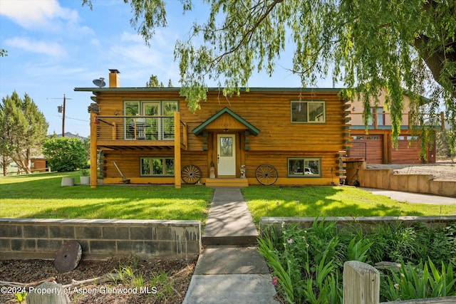 view of front of property featuring a front yard and a balcony