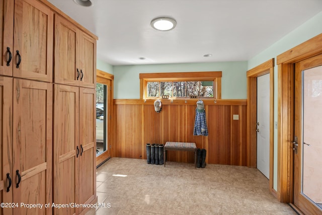 mudroom featuring wooden walls