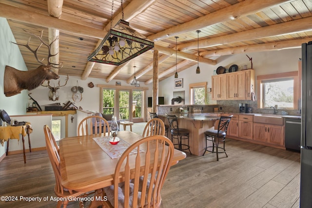 dining space featuring vaulted ceiling with beams, sink, wooden ceiling, and light wood-type flooring