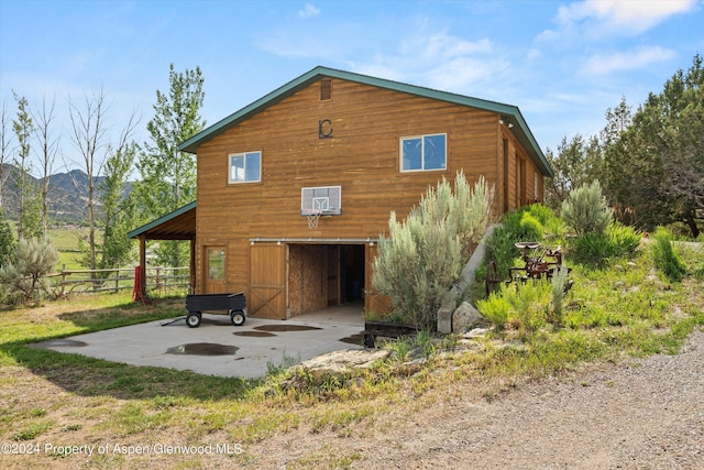 rear view of property featuring a mountain view and an outbuilding