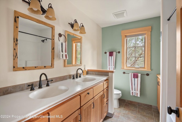 bathroom featuring vanity, toilet, and walk in shower