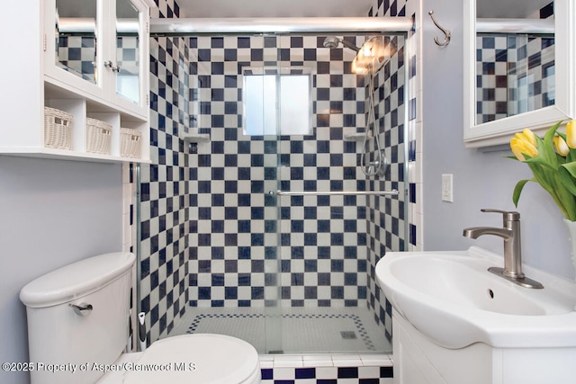 bathroom with vanity, a shower with door, and toilet