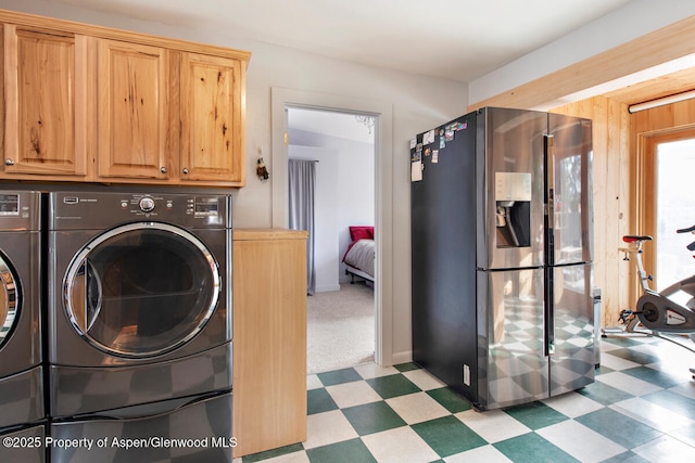 washroom featuring cabinets and washer and clothes dryer