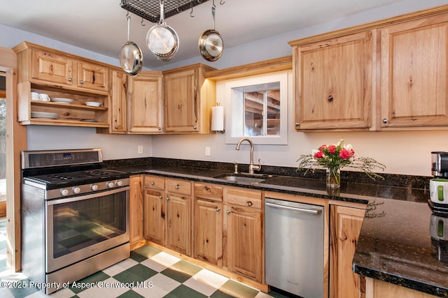 kitchen featuring pendant lighting, sink, dark stone counters, and appliances with stainless steel finishes