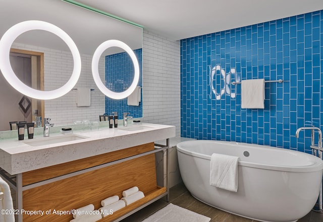 bathroom featuring a bathing tub, vanity, and tile walls