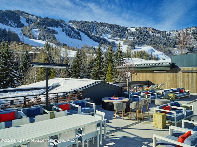 exterior space featuring a mountain view and an outdoor living space with a fire pit