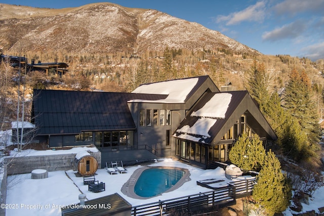 snow covered property featuring a patio area and a mountain view