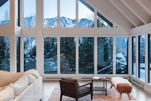 sunroom featuring a baseboard heating unit, a mountain view, and lofted ceiling with beams