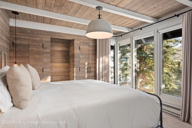 bedroom with multiple windows, beam ceiling, and wooden walls