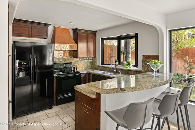 373 Sopris Creek Rd Unit 6, Basalt, CO 81621 - kitchen featuring black appliances, custom exhaust hood, a peninsula, plenty of natural light, and recessed lighting