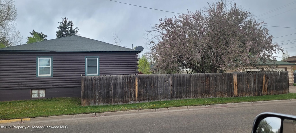 586 Tucker St, Craig, CO 81625 - view of side of property featuring fence, log siding, and a shingled roof