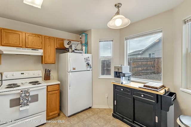 kitchen with under cabinet range hood, white appliances, light countertops, brown cabinets, and pendant lighting