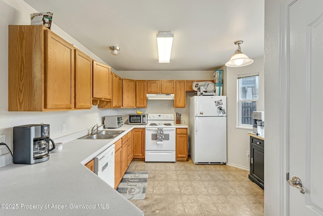 kitchen with white appliances, under cabinet range hood, light countertops, and a sink