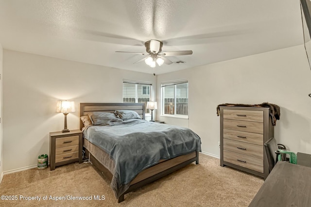 bedroom featuring ceiling fan, baseboards, visible vents, and light colored carpet