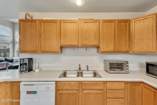 kitchen with dishwasher, light countertops, and a sink