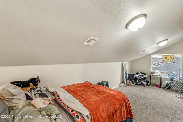 carpeted bedroom featuring a textured ceiling, vaulted ceiling, visible vents, and baseboards