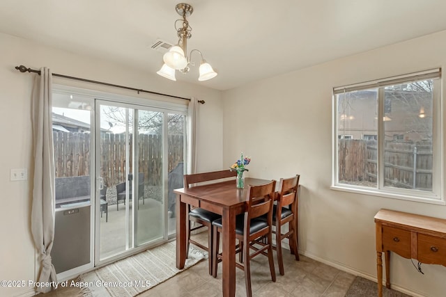 dining space with baseboards, visible vents, and an inviting chandelier