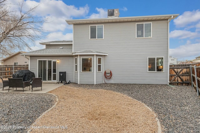 back of property featuring a fenced backyard, central AC, and a patio