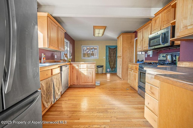 kitchen featuring stainless steel appliances, beamed ceiling, a peninsula, and light wood-style flooring